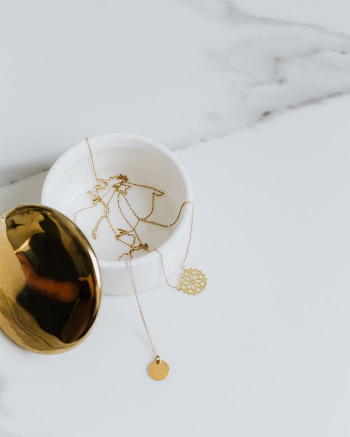 Minimalist gold necklaces displayed on a marble surface