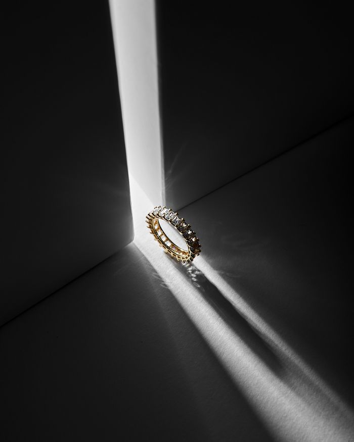 Gold ring with diamond detailing photographed in dramatic light